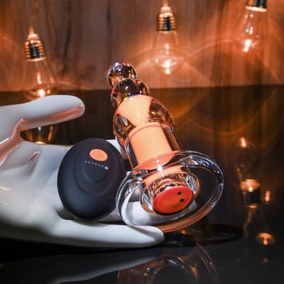 Plug Anal Recarregável Transparente com Cápsula Interna, 10 Modos de Vibração e Controle Remoto - Gender X Orange Dream | 10 x 3,5 cm